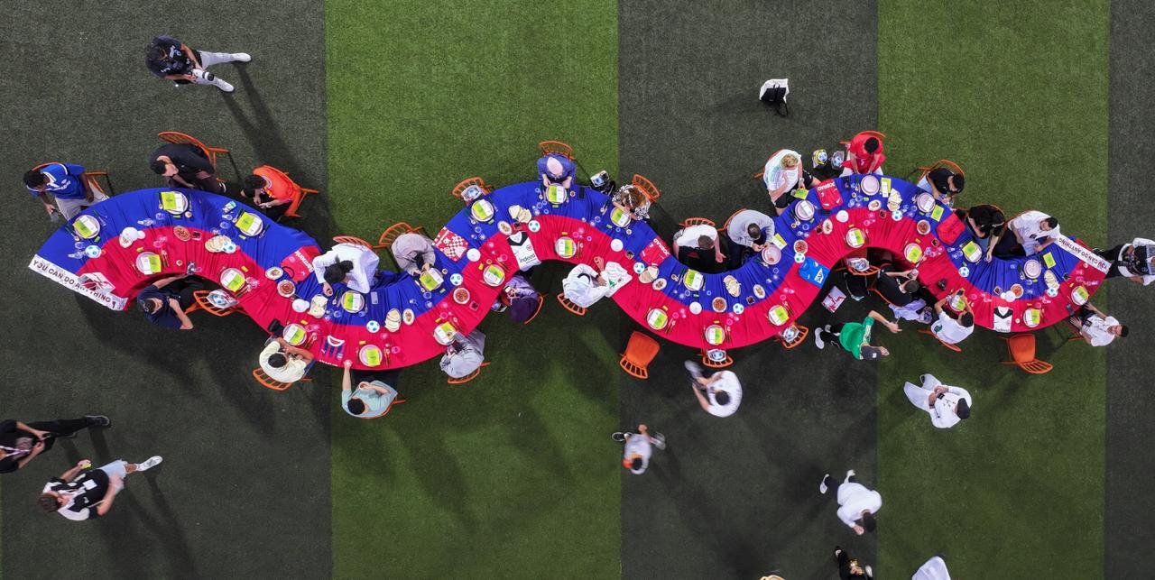 Aerial view of a serpentine banquet table on a football pitch