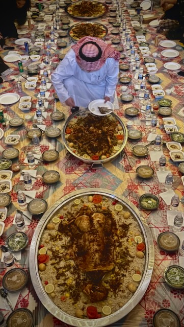 A long floor-laid feast being served